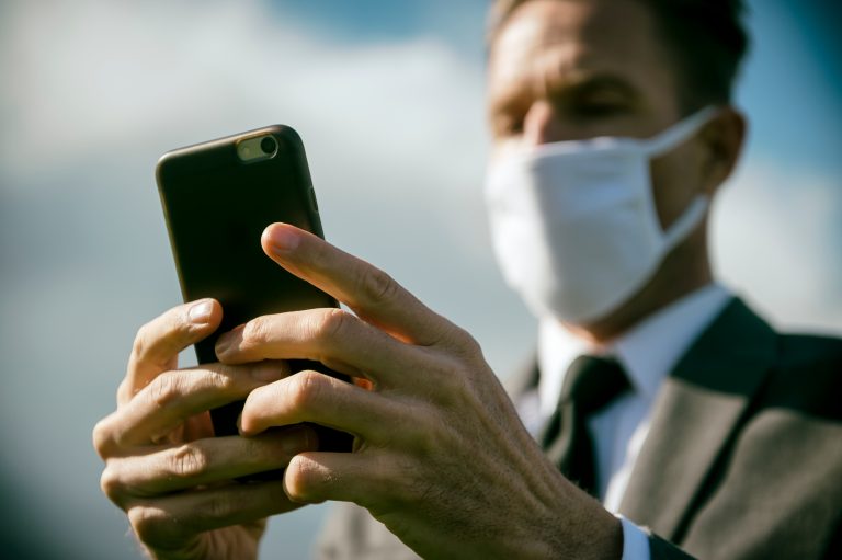 Man with a mask checking his phone